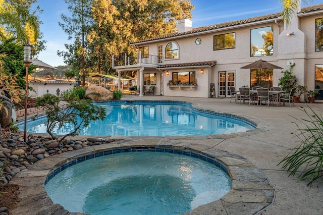 view of pool featuring a patio area and an in ground hot tub