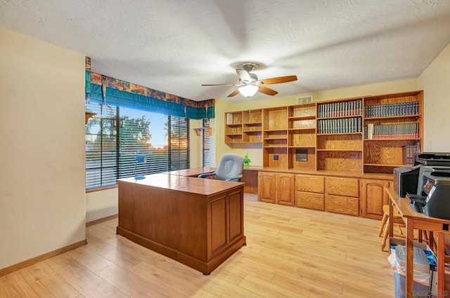 office space with ceiling fan, a textured ceiling, and light wood-type flooring