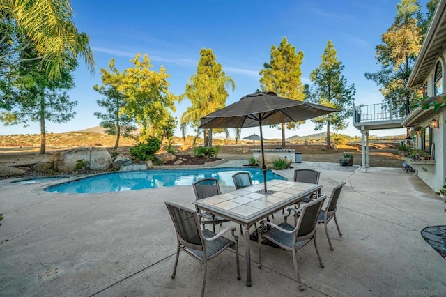 view of swimming pool with a mountain view and a patio