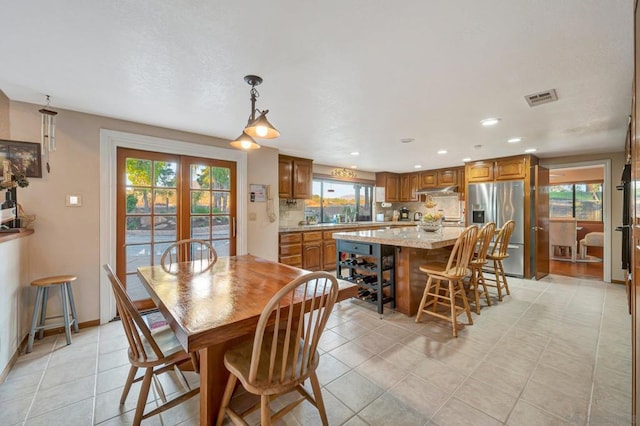 dining space with light tile patterned floors and french doors