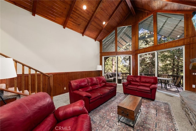 living room with carpet flooring, wooden walls, beamed ceiling, and high vaulted ceiling