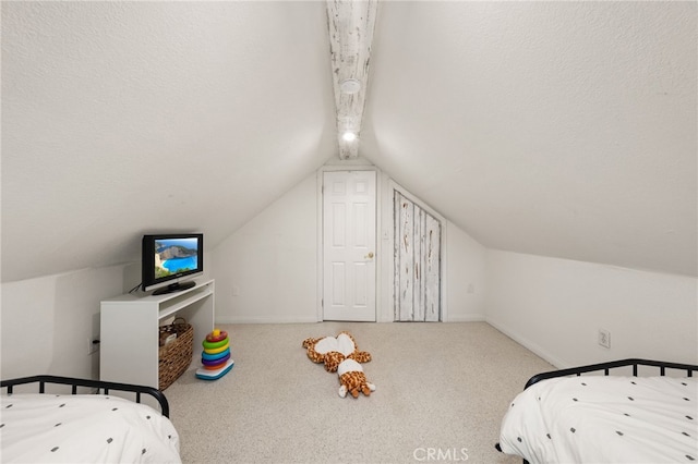 carpeted bedroom featuring a textured ceiling and vaulted ceiling