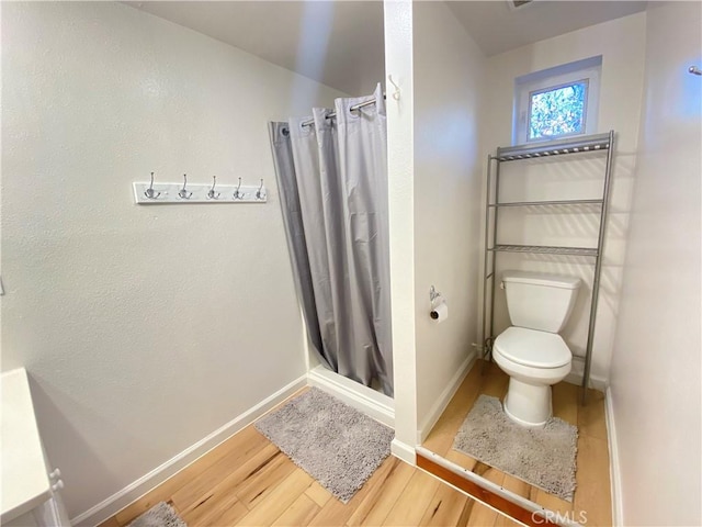 bathroom featuring a shower with shower curtain, wood-type flooring, and toilet