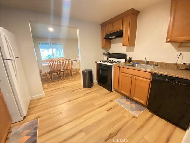 kitchen with sink, light hardwood / wood-style flooring, and black appliances