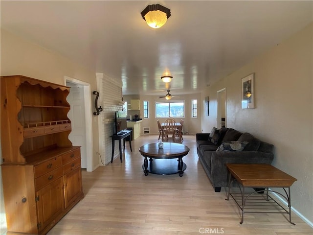 living room with ceiling fan and light hardwood / wood-style floors