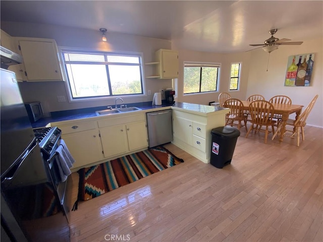 kitchen with sink, ceiling fan, light wood-type flooring, appliances with stainless steel finishes, and kitchen peninsula