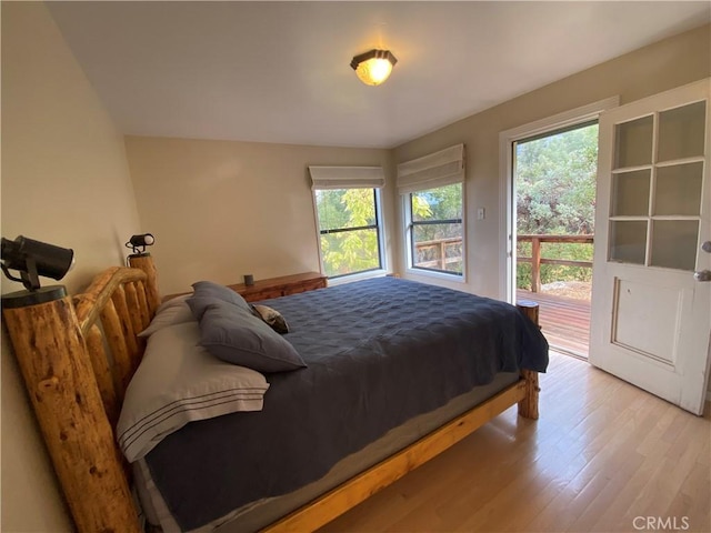 bedroom featuring light hardwood / wood-style floors, access to exterior, and multiple windows