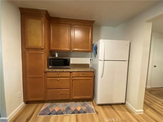 kitchen with light hardwood / wood-style flooring and white refrigerator