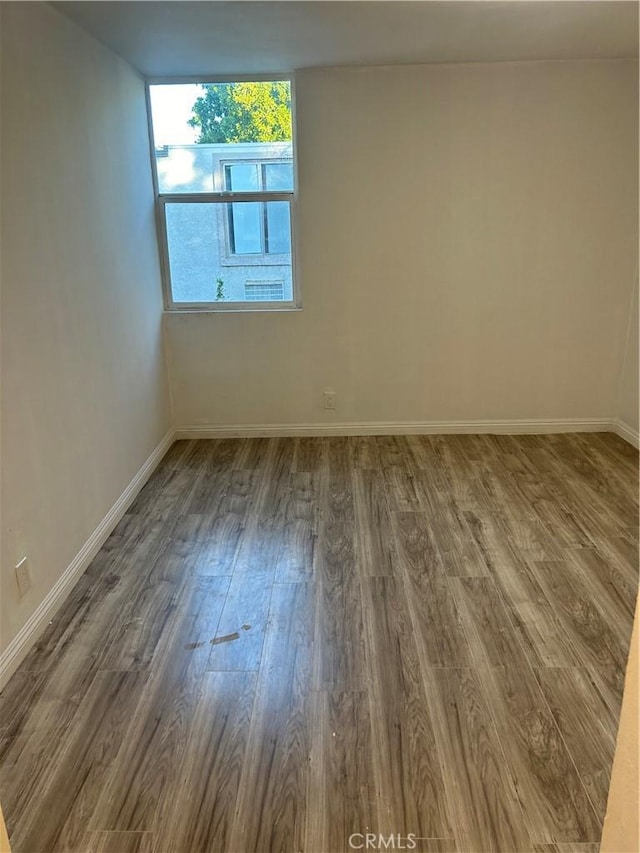 spare room with wood-type flooring