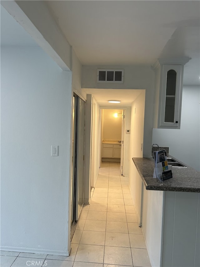 hallway with light tile patterned flooring and sink