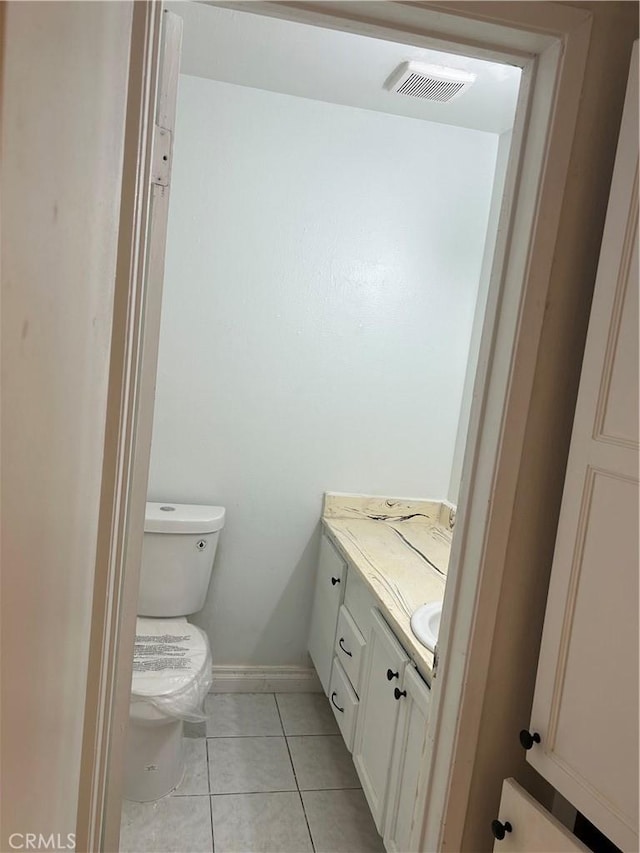 bathroom featuring tile patterned flooring, vanity, and toilet