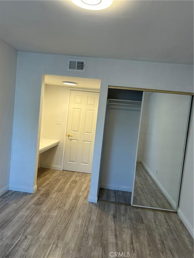 unfurnished bedroom with dark hardwood / wood-style flooring and a closet