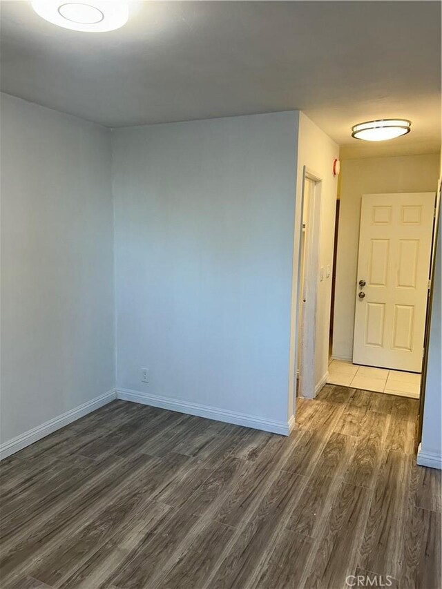 unfurnished room with dark wood-type flooring