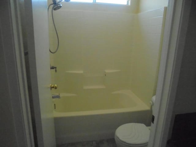 bathroom featuring bathing tub / shower combination and toilet