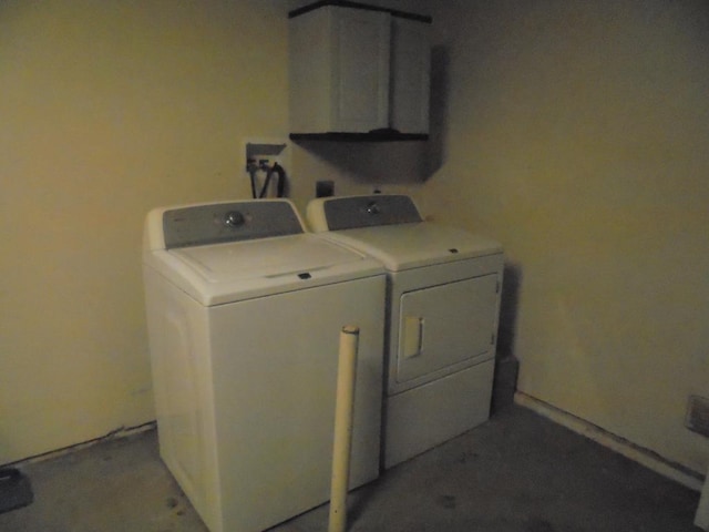 laundry room featuring washer and clothes dryer and cabinets