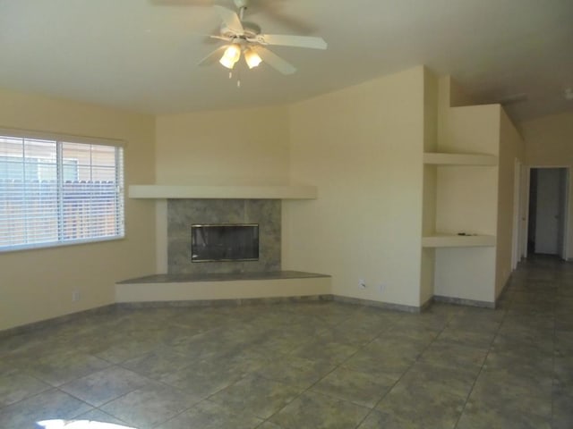 unfurnished living room with a tile fireplace, tile patterned floors, and ceiling fan