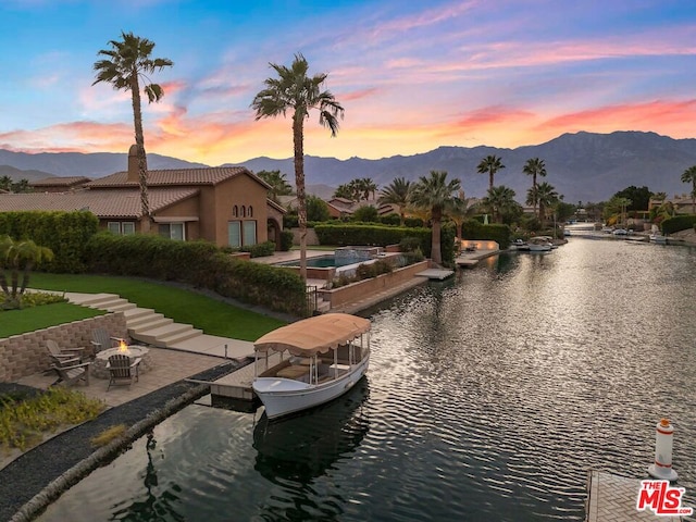 water view featuring a mountain view, a dock, and a fire pit