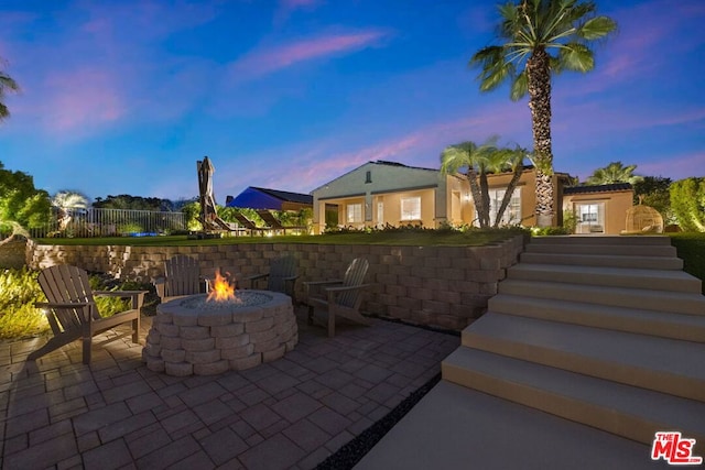 patio terrace at dusk featuring an outdoor fire pit