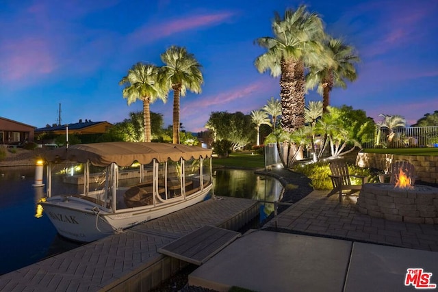 view of dock featuring a patio area, a water view, and an outdoor fire pit