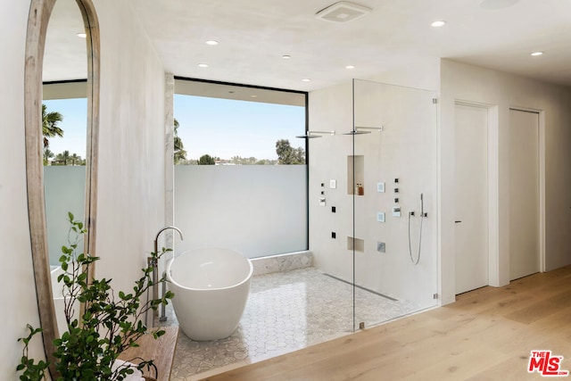 bathroom with a bathtub and hardwood / wood-style flooring