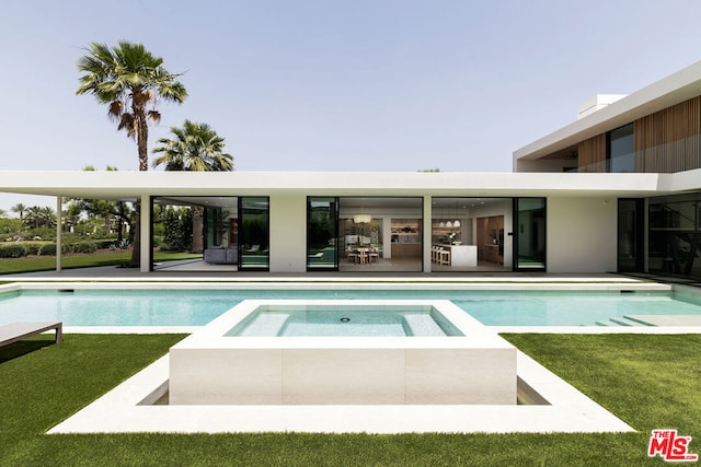 view of pool featuring an in ground hot tub and a yard