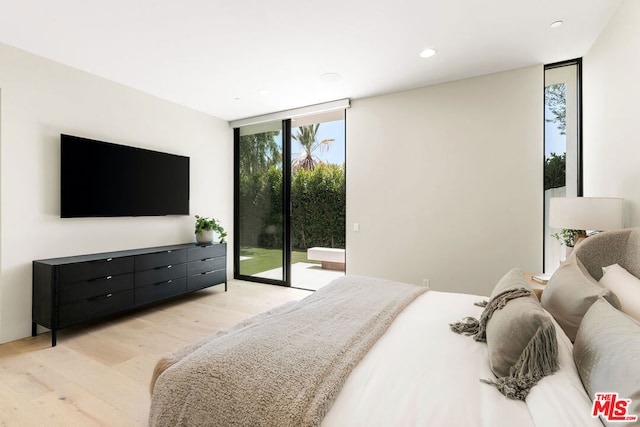 bedroom featuring access to outside, expansive windows, and light hardwood / wood-style floors