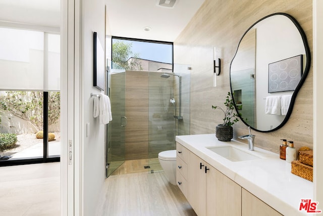 bathroom with backsplash, vanity, an enclosed shower, and toilet