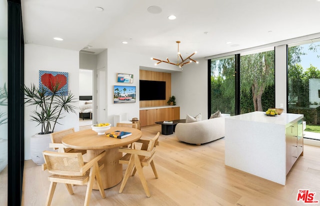 dining space with an inviting chandelier, light hardwood / wood-style flooring, and floor to ceiling windows