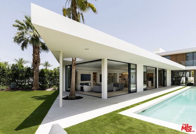 view of pool featuring a lawn, outdoor lounge area, and a patio area