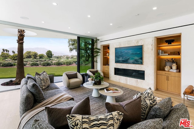 living room with built in features and light wood-type flooring