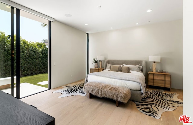 bedroom with access to outside and light wood-type flooring