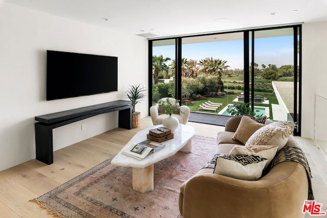 living room featuring a wall of windows and light hardwood / wood-style flooring