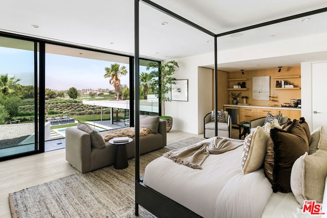 bedroom with expansive windows, access to exterior, and light wood-type flooring