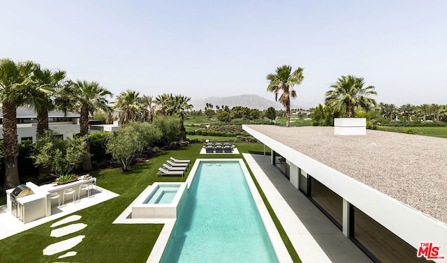 view of swimming pool with a mountain view and a yard