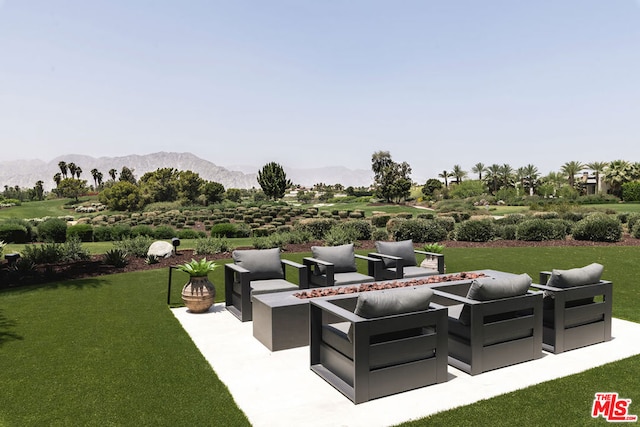 view of patio / terrace featuring a mountain view and an outdoor living space with a fire pit