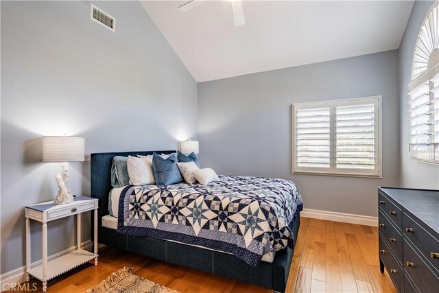 bedroom with ceiling fan, vaulted ceiling, wood-type flooring, and multiple windows