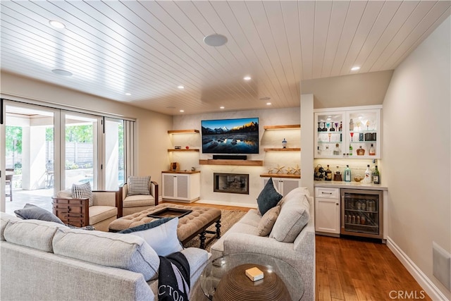 living room with dark hardwood / wood-style floors, wood ceiling, beverage cooler, and bar area