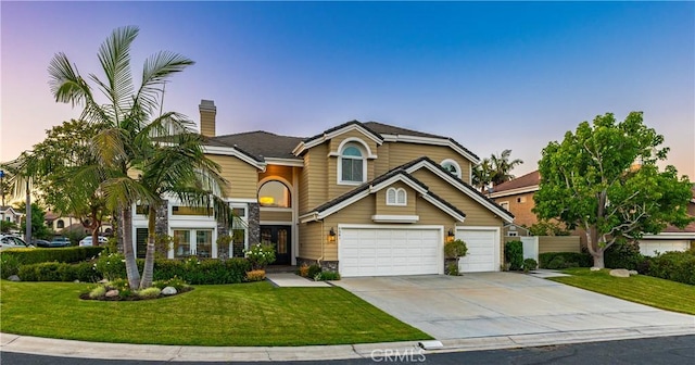 front of property featuring a lawn and a garage