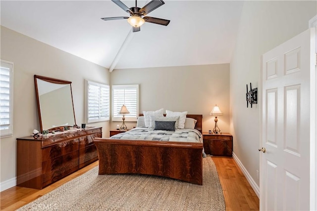 bedroom featuring light wood-type flooring, vaulted ceiling, and ceiling fan