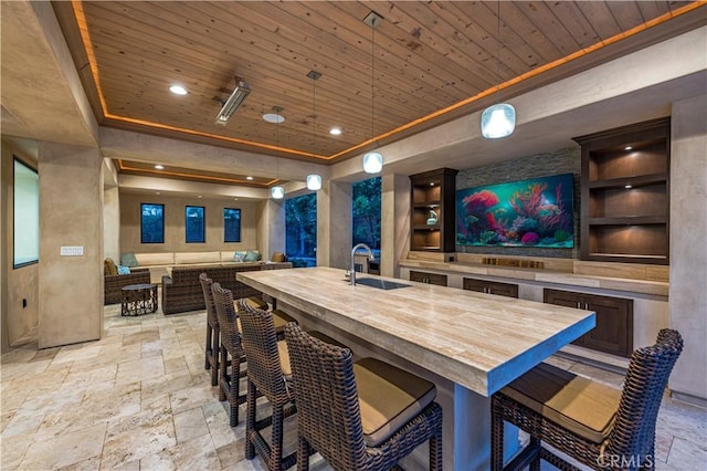 dining room with a raised ceiling, wooden ceiling, and sink