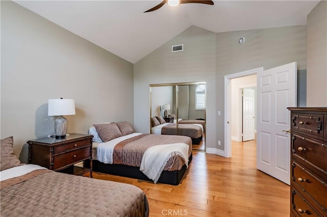 bedroom featuring a closet, ceiling fan, light hardwood / wood-style flooring, and high vaulted ceiling