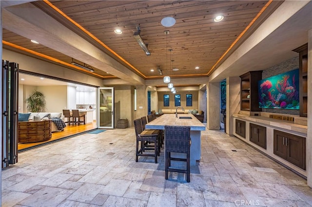 dining room featuring crown molding, wood ceiling, sink, and a tray ceiling