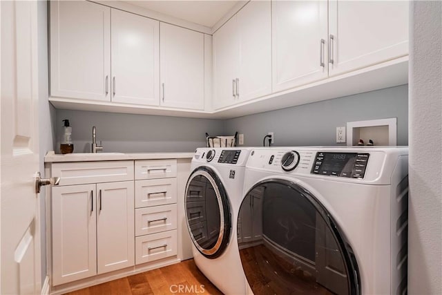 laundry room with separate washer and dryer, light hardwood / wood-style floors, cabinets, and sink