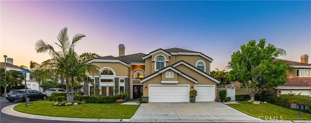 front of property featuring a lawn and a garage