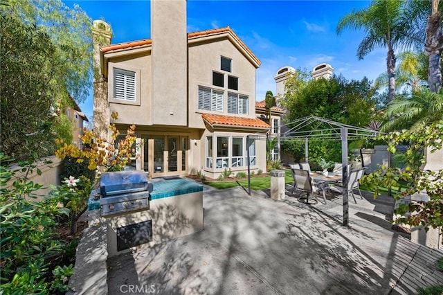 rear view of property featuring a gazebo and a patio area