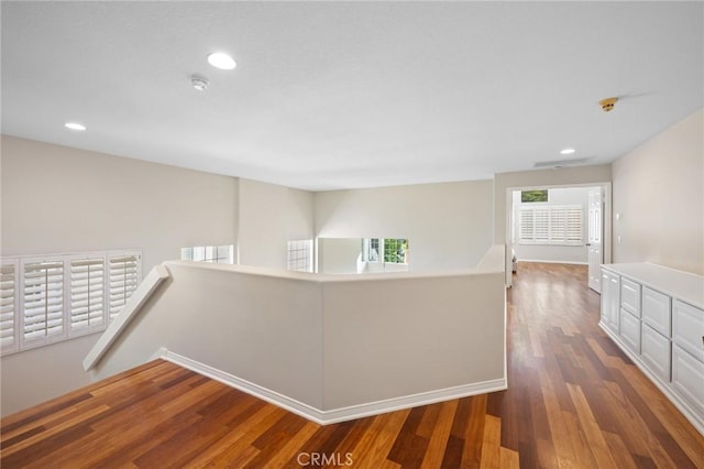 corridor with dark hardwood / wood-style flooring