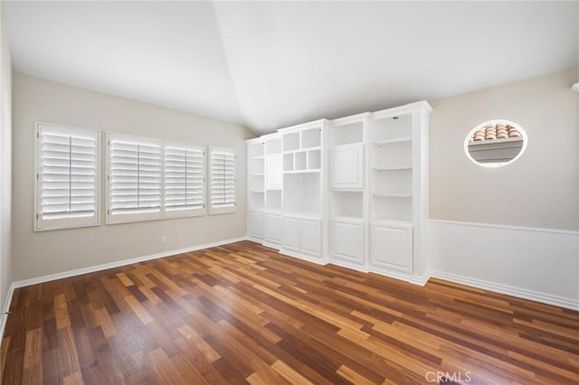 unfurnished room featuring lofted ceiling and dark wood-type flooring