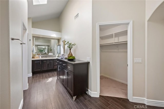 bathroom with vanity, high vaulted ceiling, and wood-type flooring