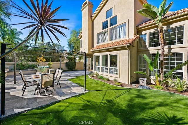 back of property featuring a patio and a lawn