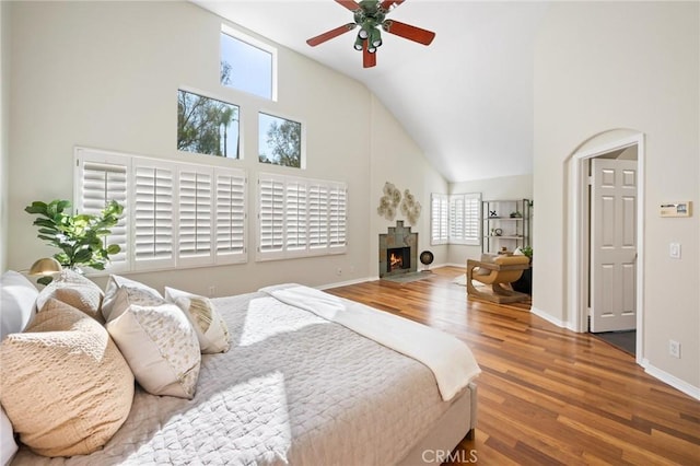 bedroom with hardwood / wood-style floors, high vaulted ceiling, and ceiling fan